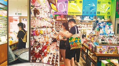 北京某商场里，“好运冰箱贴”、“喜上眉梢”喜鹊发卡等具有情绪价值的商品琳琅满目，消费者正在选购。孙艺纯摄